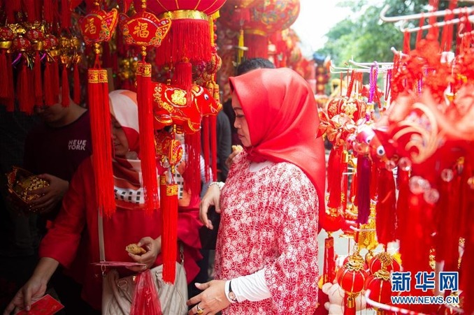 这是2019年2月4日农历春节前夕,一位当地居民在印度尼西亚雅加达唐人街选购春节传统装饰物。 新华社记者 杜宇 摄