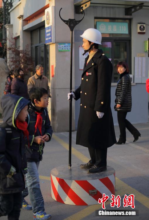 帅气的保安手持钢叉站在大门口执勤,威风凛凛护卫学生安全