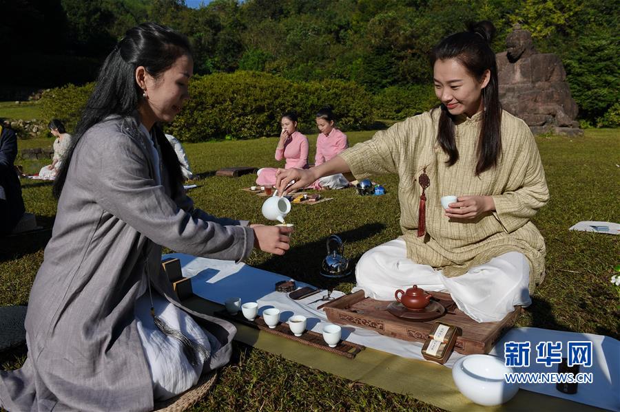 身著古朴服饰的福建武夷山茶人在户外摆茶席,在空气清新的大自然裏