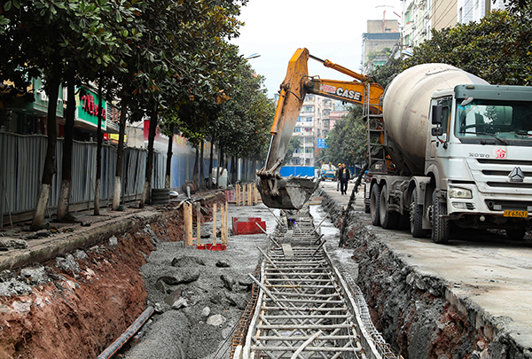 图片默认标题_fororder_华蓥市实施管网改造的工人在红星三路给刚铺设好的管网浇灌混凝土