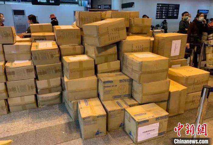 中新网@旅行团分摊重量从泰搬146箱防护服 娃也当起搬运工