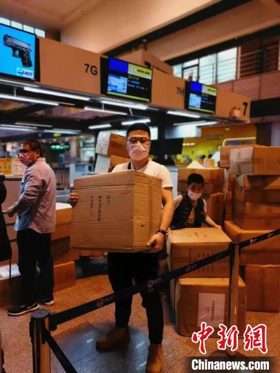 中新网@旅行团分摊重量从泰搬146箱防护服 娃也当起搬运工