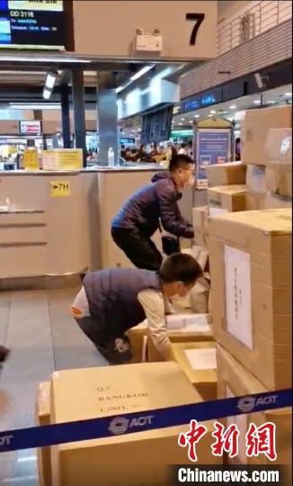 中新网@旅行团分摊重量从泰搬146箱防护服 娃也当起搬运工