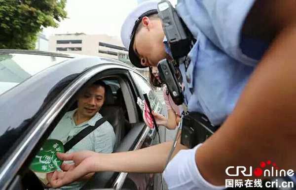 图片默认标题_fororder_交警给文明礼让车，贴“车让人-点赞”车贴。（成都市交管局-供图）