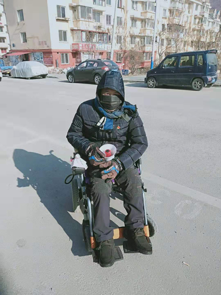 “中国好人”马占路坐着电动轮椅宣传疫情防护工作