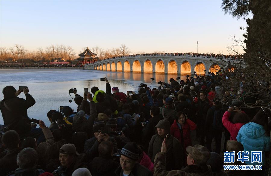 12月23日，游客和攝影愛好者在拍攝頤和園十七孔橋“金光穿洞”美景。 當日，北京頤和園十七孔橋出現(xiàn)“金光穿洞”美景，吸引許多游客和攝影愛好者前來觀賞拍攝。 新華社記者陳曄華攝