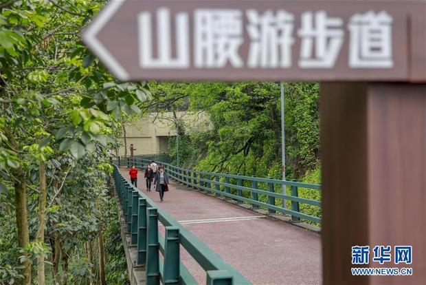 游客沿著重庆半山崖线步道的虎头岩段前行(4月3日摄).