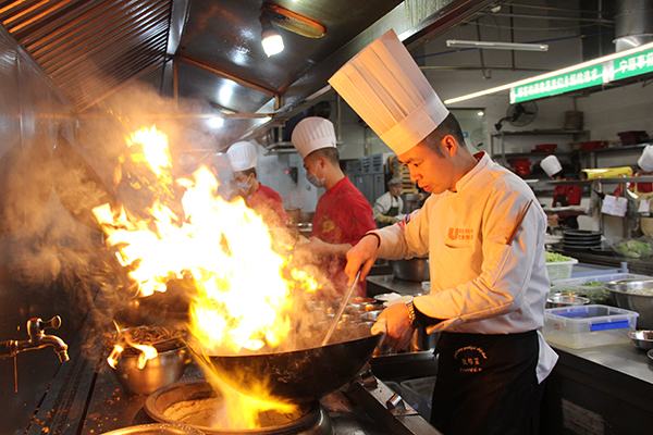 图片默认标题_fororder_何伟正在烹饪菜肴（摄影-杨梦婧）