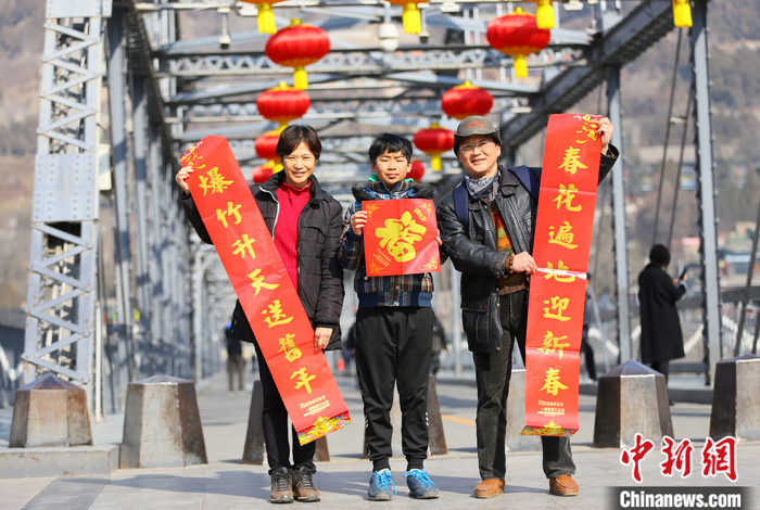 两岸经贸合作进一步增强是不可阻挡之大势_fororder_　　2021年春节期间，台湾夫妻杜书亿和王梅芬带着孩子一起在兰州中山铁桥前合影留念。 中新社记者 高展 摄