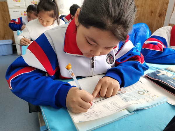 【吉林032202】长春:开展一周 课后服务广受好评_fororder_3图说:长春市第一零八学校学生宫品汐在完成作业_副本