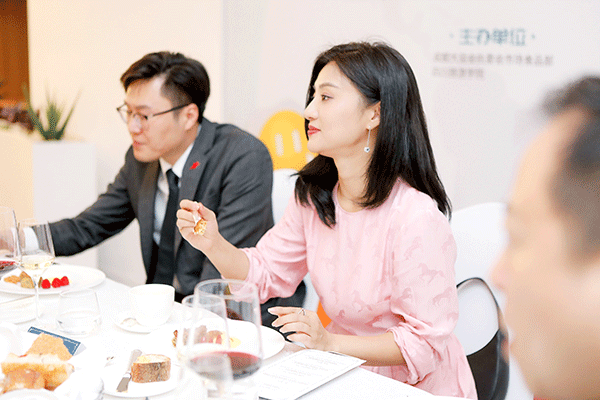 赛事之美与美食之美交流互鉴 成都举行国际赛事运动员经典餐饮服务评鉴会_fororder_嘉宾品尝美食-供图-成都大运会执委会