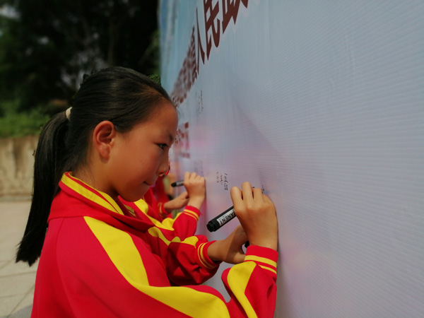 图片默认标题_fororder_学生们签名助力文明城市创建