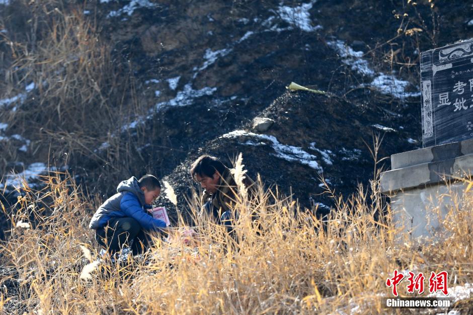 2月7日是除夕,在陕西省泾阳县高庄镇,村民们手提纸钱鞭炮,前往上坟