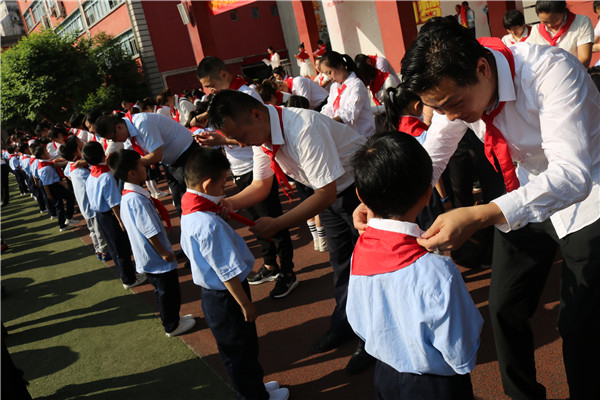 图片默认标题_fororder_家长为孩子佩戴红领巾（成都市簇桥小学-供图）
