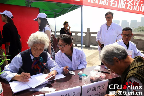 图片默认标题_fororder_2017年5月4日，王立玉参加社区组织的公益活动，为居民建立健康档案（犍为宣传部供图）