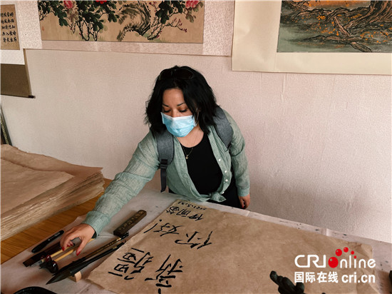 (外籍记者新疆行)记者手记:传承至今的造纸“活化石”——和田桑皮纸工艺_fororder_保加利亚外籍记者伊闻笛在桑皮纸上写祝福
