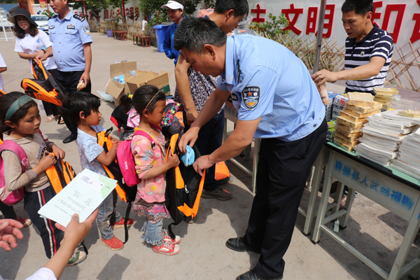 图片默认标题_fororder_民警为孩子送上爱心书包--供图--凉山州喜德县公安局
