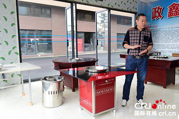 图片默认标题_fororder_彭朝继正在介绍智能升降火锅餐桌。