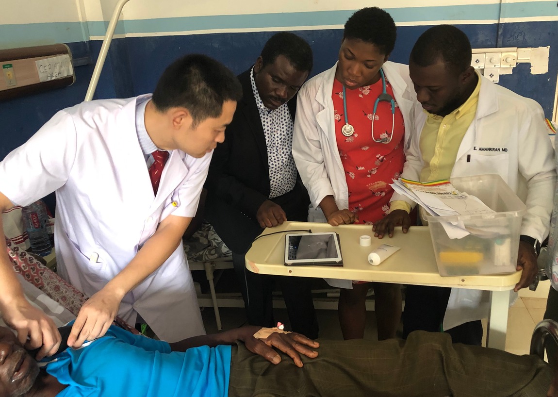 图片默认标题_fororder_中国援加纳医疗队神经内科王荣飞医生（左），给当地医生演示超声检查。医疗队供图