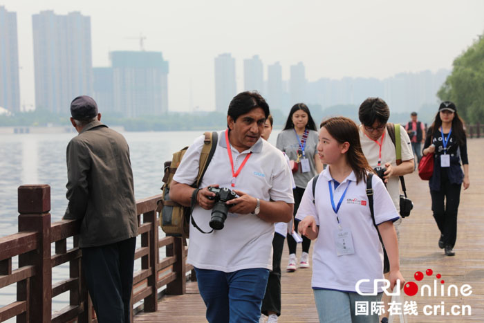图片默认标题_fororder_来自沈阳城市学院的志愿者（右一）为外籍摄影师讲解。摄影  张宇鹏