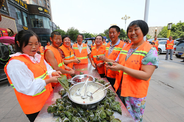 图片默认标题_fororder_图为中江县环卫工人放下劳动工具在活动现场兴高采烈包粽子