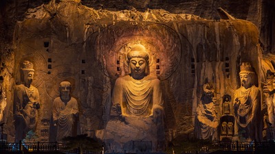 Ancient Buddha statues shine under modern lights at night
