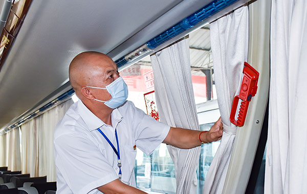 四川自贡:为20余万乘客保驾护航 劳动模范甘德富19年驾驶零事故_fororder_3甘德富仔细整理窗帘(摄影-赵丽)