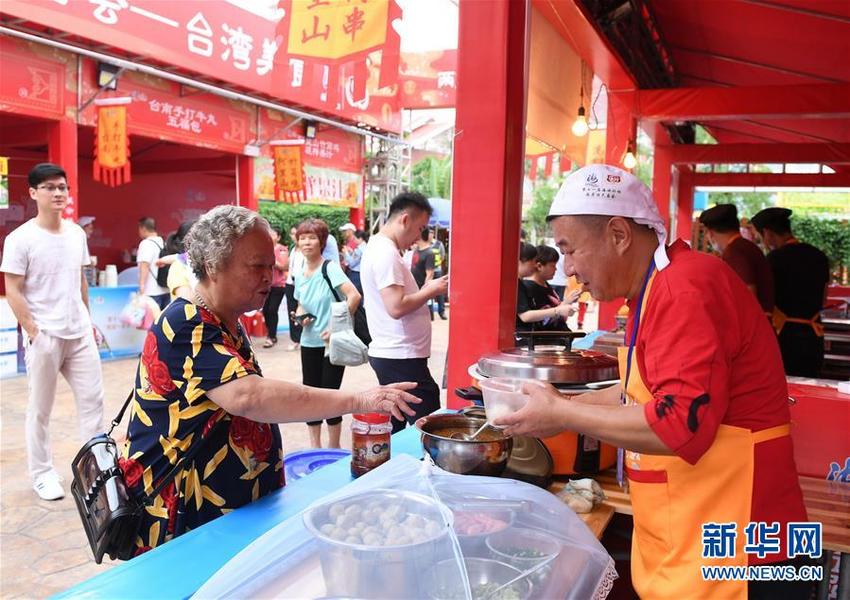 6月14日，廈門市民在兩岸特色廟會上品嘗臺灣美食。當日，第十一屆海峽論壇·兩岸特色廟會在廈門舉行。新華社記者 林善傳 攝