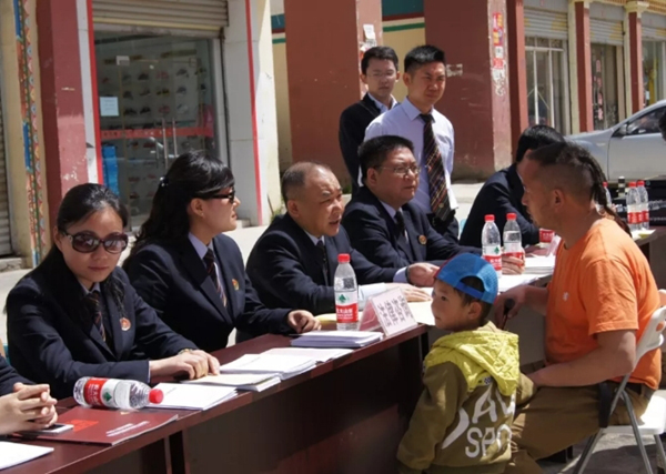 图片默认标题_fororder_李勇（左三）为藏族小伙解答法律问题--成都市律政公证处供图