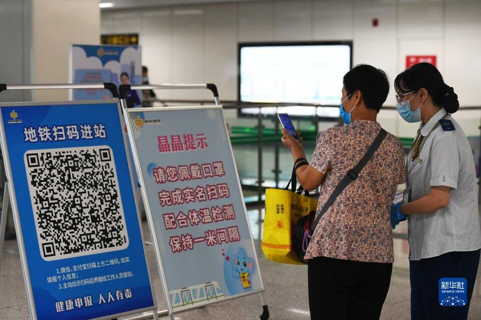 9月15日,郑州地铁5号线工作人员帮助乘客扫码.新华社记者 张浩然 摄