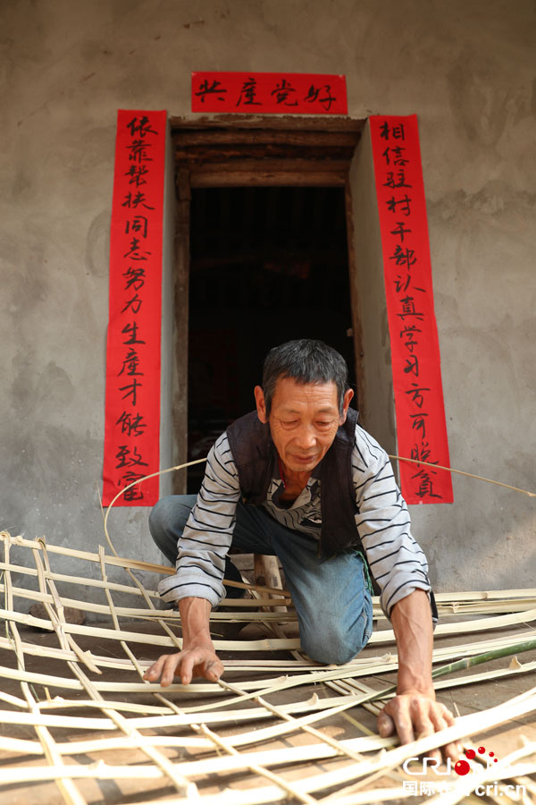 图片默认标题_fororder_蒋元彬老人在鲜红的对联下舒心地干着篾活