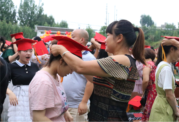 图片默认标题_fororder_家长为子女冠礼帽、拨穗（成都市金堂县高板中学 供图）