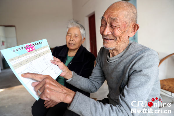 图片默认标题_fororder_华蓥市明月镇刘家庙村6组易地扶贫搬迁户熊国银老人与老伴唐文翠,在安全舒适的新房内开心地展示他一家人享受到的党和政府给予的扶贫政策