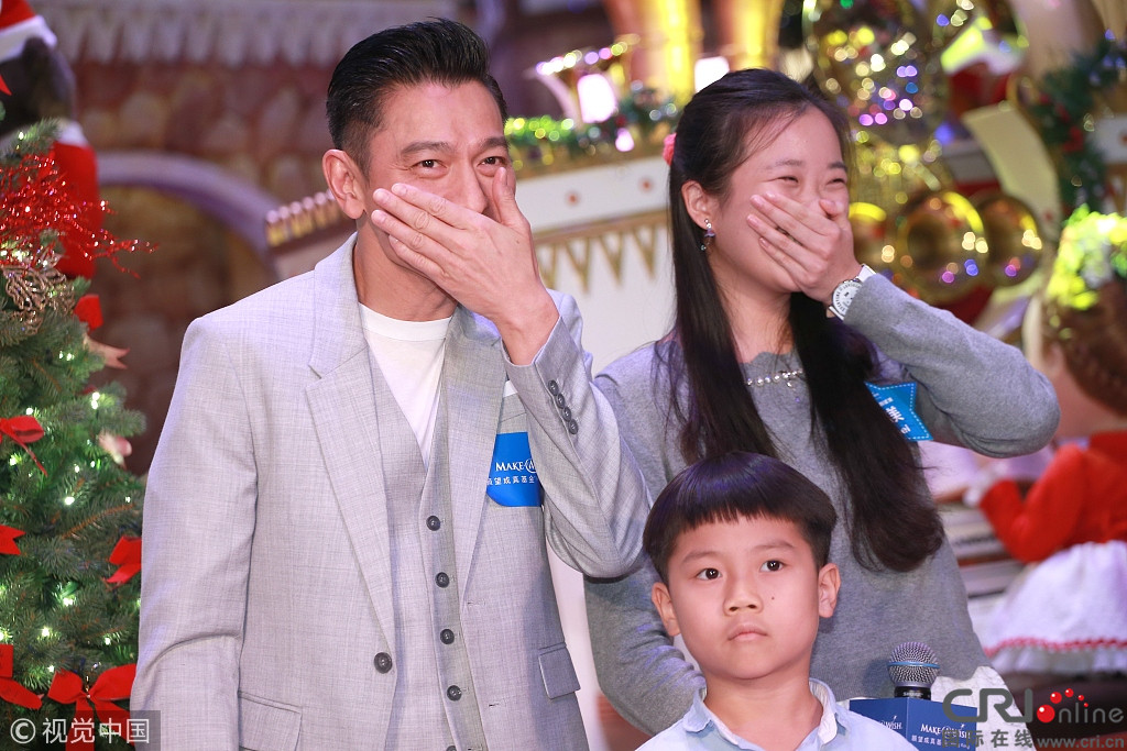 刘德华出席义卖募款活动与受助儿童组"一家三口"