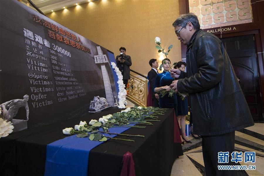 12月9日，在加拿大多伦多，一名男子在纪念南京大屠杀80周年追思会上献花。（新华社 邹峥摄）
