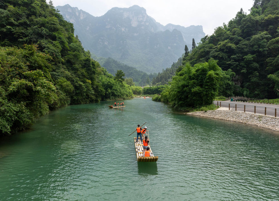 6月26日,游客在湖北秭归三峡竹海生态风景区内体验竹筏亲水项目.