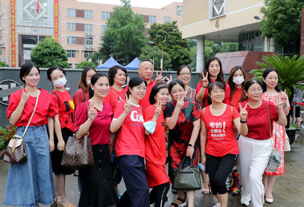 一些送考的老师和学生家长在上海七宝中学考点外合影.