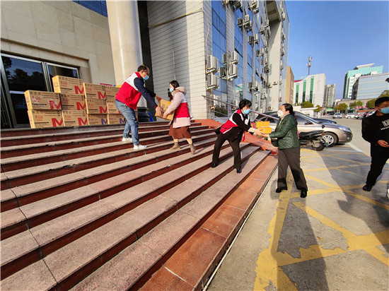 浉河区红十字会向战“疫”一线捐赠物资_fororder_浉河区红十字会工作人员搬运物资装车。