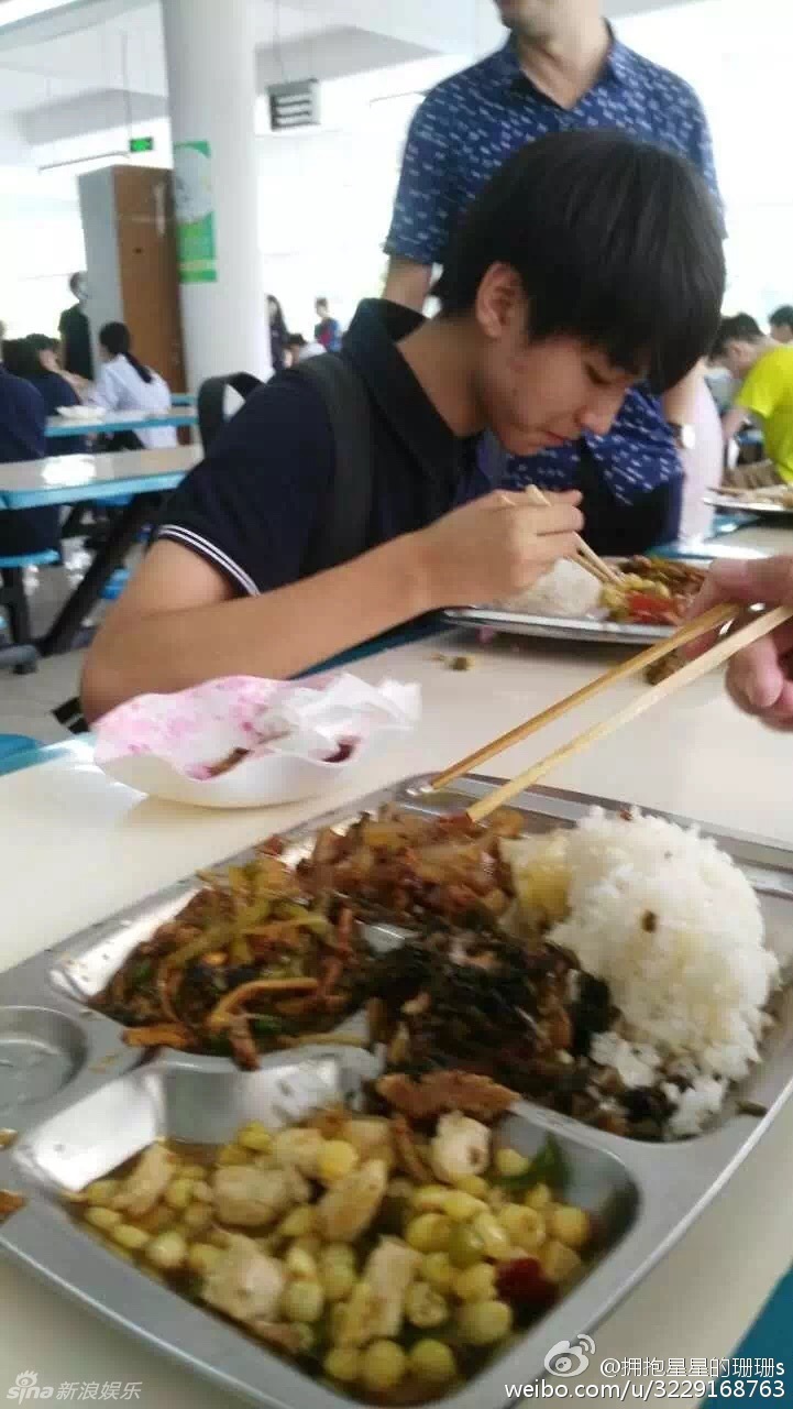 组王俊凯在高中校园的照片,照片中王俊凯背着书包穿着校服在食堂吃饭