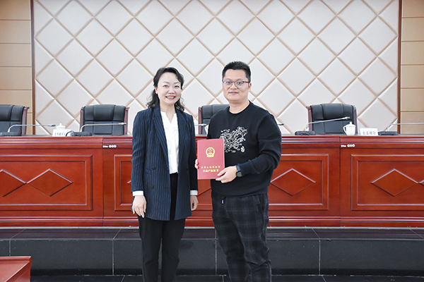 自贡首宗“交地即交证”项目实现 高新营商环境进入“加速度”_fororder_3自贡市自然资源和规划局党委委员、副局长韦媛媛(左)向企业颁发不动产权证书(摄影-赵丽)