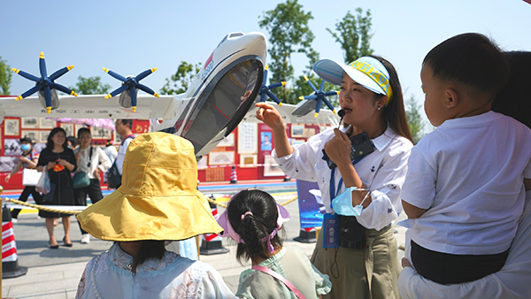 中国航天日 青少年感受“沉浸式”航天文化_fororder_崔海燕正在向孩子们介绍航天设备_毒霸看图