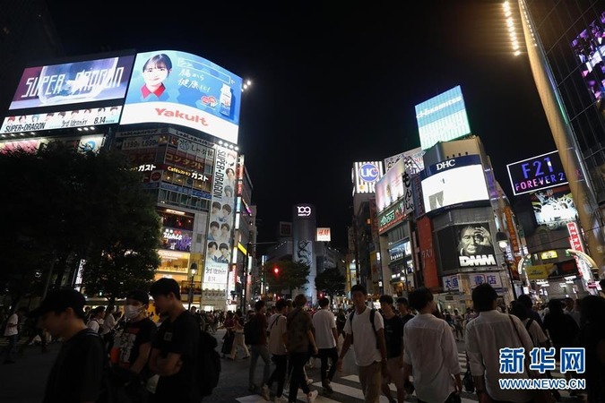 8月17日夜晚，在日本東京，人們走過澀谷街頭的十字路口。新華社記者 杜瀟逸 攝