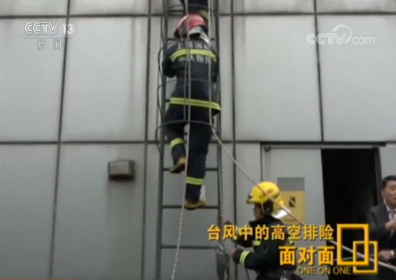 面对面 | 半个身子探出150米高空 冒强风排险后消防员硬汉相拥而