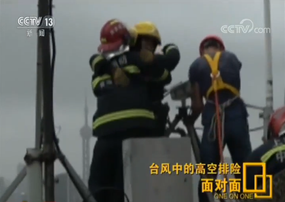 面对面 | 半个身子探出150米高空 冒强风排险后消防员硬汉相拥而