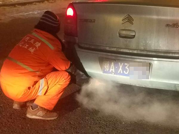 环卫工蹲出租车排气管暖手 受邀上车又下车:怕弄脏