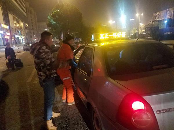 环卫工蹲出租车排气管暖手 受邀上车又下车:怕弄脏