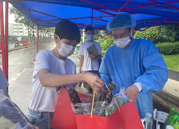 成都疫情防控现场 封控区有个暖心“跑跑队”_fororder_“跑跑队”队员将采买的物资送到小区门口-供图-天府新区党群工作部