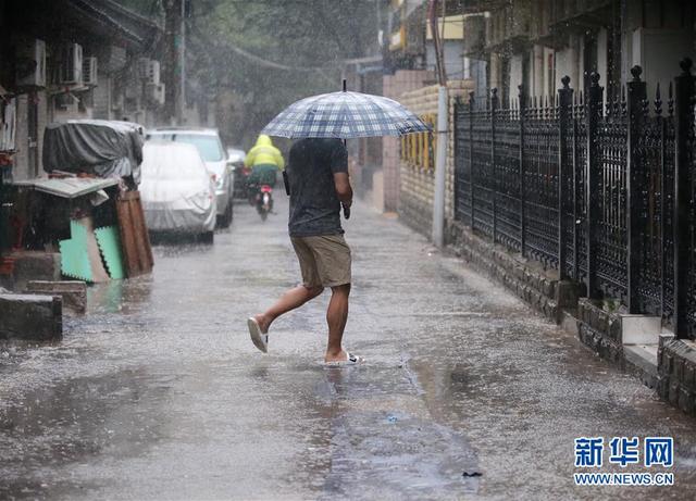 7月20日,行人在北京温家街胡同冒雨前行.新华社记者 金立旺 摄