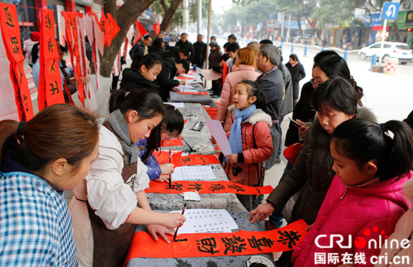 图片默认标题_fororder_华蓥市山羊书法社的学生学员为市民免费书写并赠送春联活动现场 - 副本
