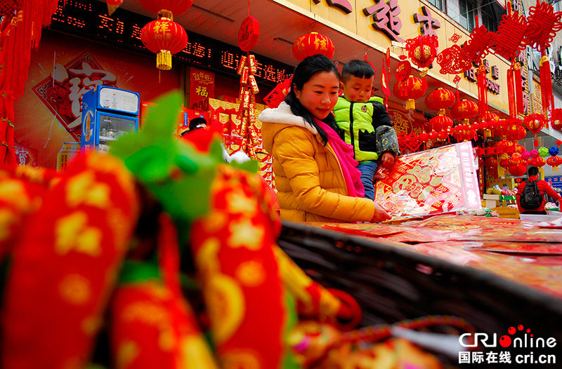 图片默认标题_fororder_2月12日上午，南充市仪陇县马鞍镇居民在集市上忙着购买春联、灯笼等过年需要的物品。（摄影-张景轩）